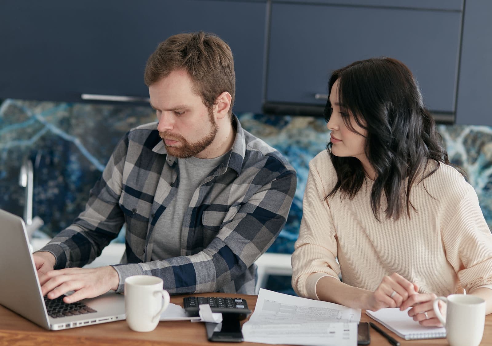 Couple examinant ses documents financiers avec un ordinateur portable
