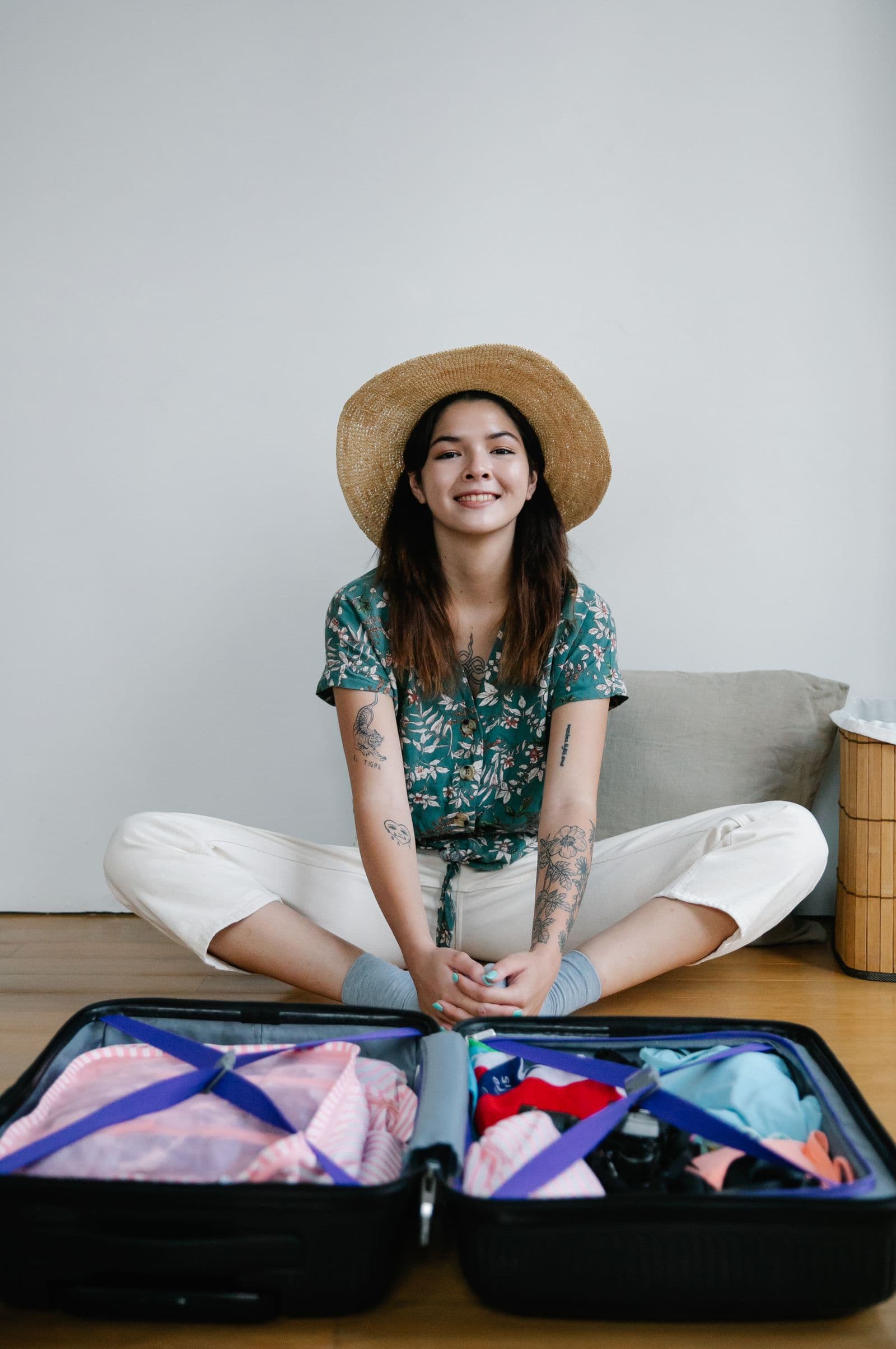 Personne souriante préparant sa valise pour un départ