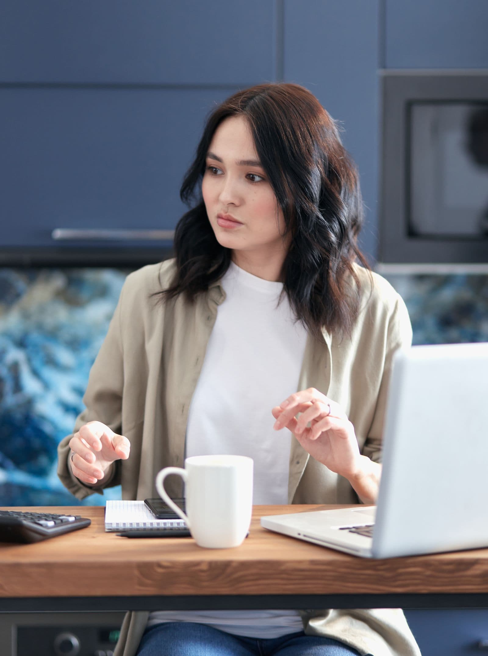 Jeune femme calculant son budget avec une calculatrice